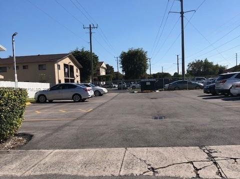 A parking lot with several parked cars sits in front of a multi-story apartment building — 1460 N 43rd Pl # 106, Hialeah FL 33012, HIALEAH, FL