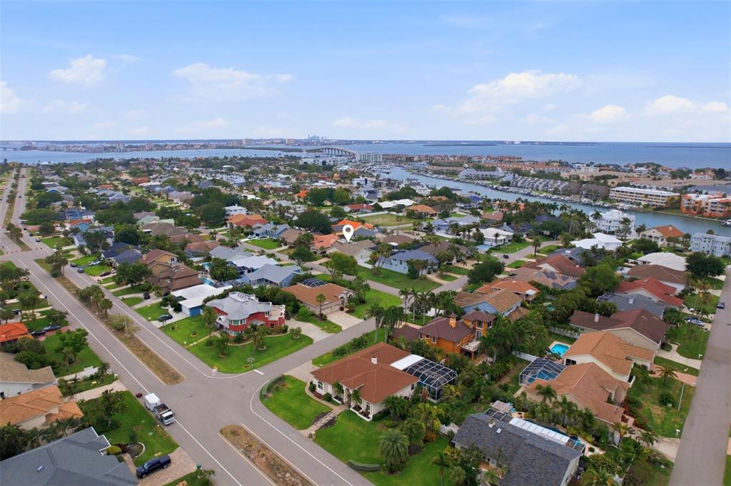 An aerial view of a suburban neighborhood with houses, streets, and a nearby waterway — 661 7TH AVENUE N, TIERRA VERDE, FL