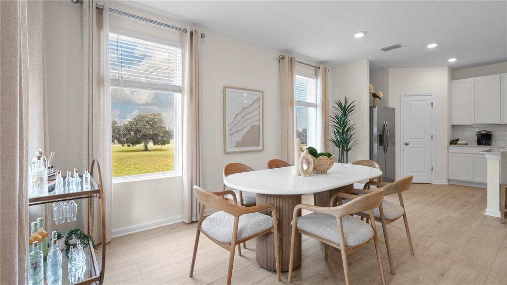 A dining area features a white oval table, wooden chairs, and a bar cart — 3141 ROCKWOOD WAY, MINNEOLA, FL