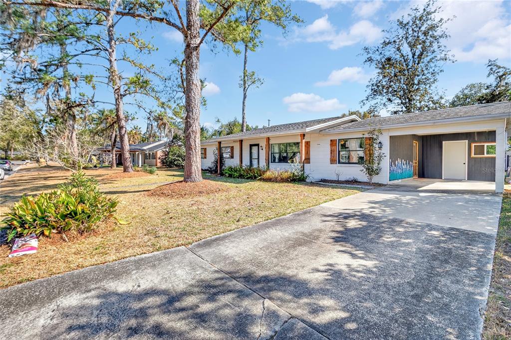 A single-story house with a white exterior, a carport, and a concrete driveway — 3321 NW 28TH PLACE, GAINESVILLE, FL