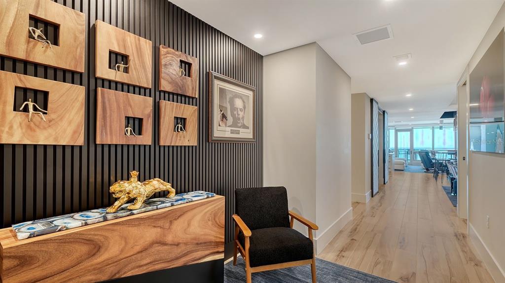 A hallway features a slatted black accent wall, wood-topped console, and a black armchair — 1035 SEASIDE DRIVE UNIT 503, SARASOTA, FL