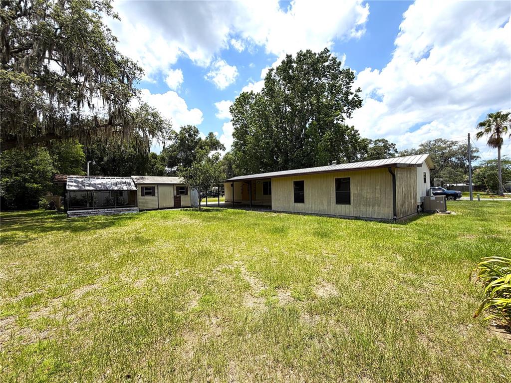 A yellow mobile home with a metal roof and a detached shed in a yard — 1355 N REED TERRACE, INVERNESS, FL
