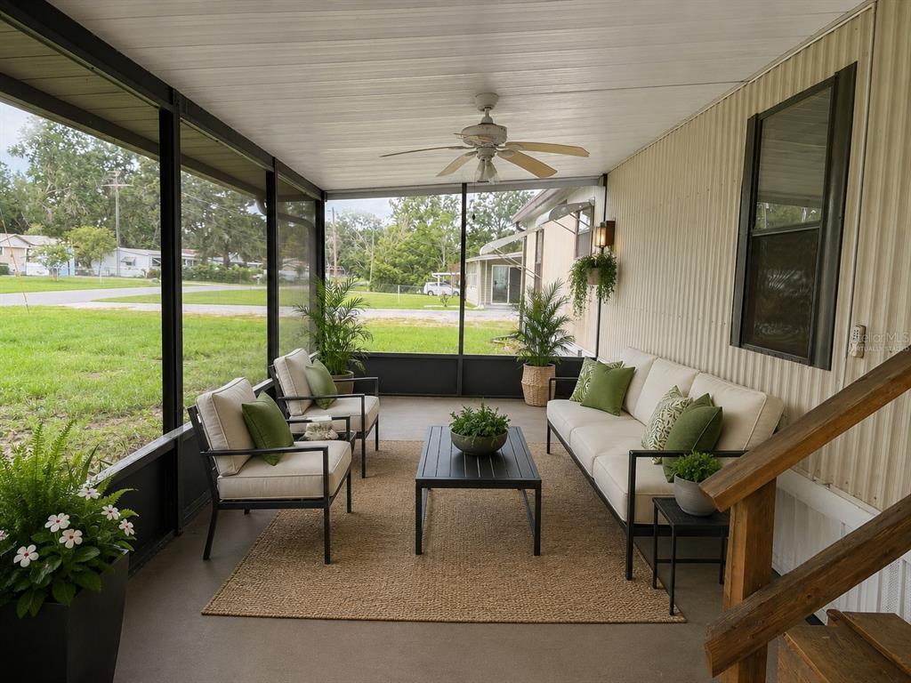 A screened-in porch features outdoor furniture, a ceiling fan, and views of a grassy yard — 1355 N REED TERRACE, INVERNESS, FL