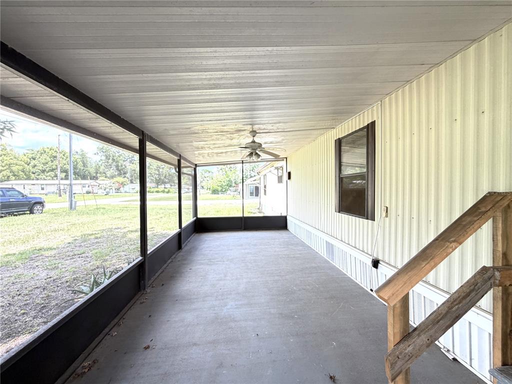 A covered, screened-in porch with a concrete floor, ceiling fan, and light-colored siding — 1355 N REED TERRACE, INVERNESS, FL