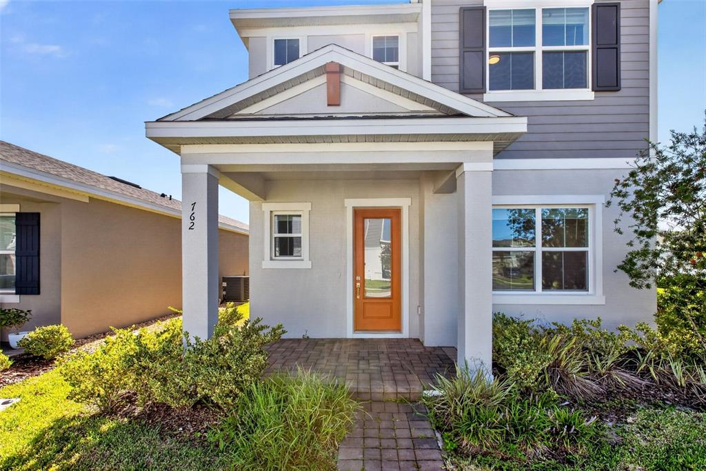 The exterior of a two-story house features a covered front porch and a wooden door — 762 MIDDLETON STREET, DEBARY, FL