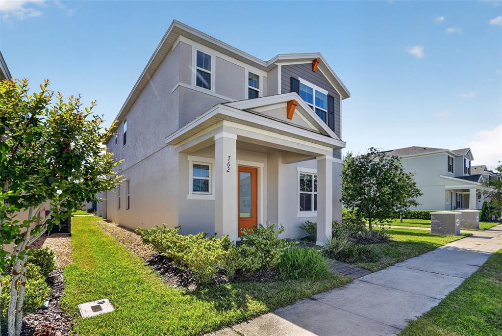 A two-story house with a gray stucco exterior, a front porch, and an orange door — 762 MIDDLETON STREET, DEBARY, FL