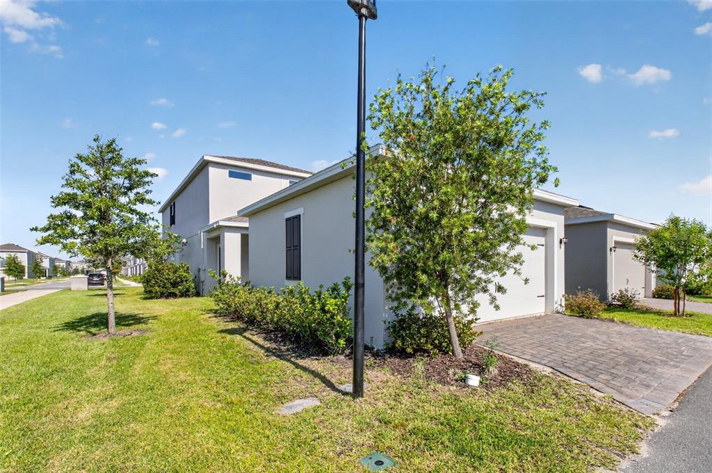 A side view of a light-colored suburban house with a paved driveway and landscaping — 762 MIDDLETON STREET, DEBARY, FL