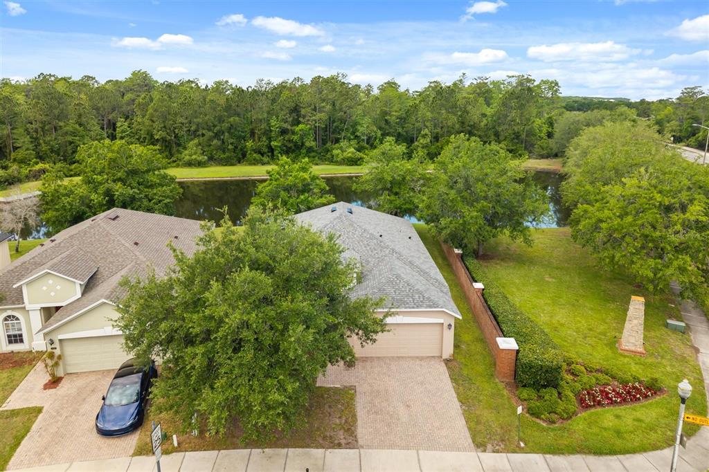 An aerial view shows two suburban houses with paved driveways next to a pond — 9406 CANDICE COURT, ORLANDO, FL