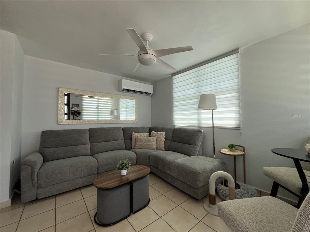 A living room features a gray sectional sofa, a coffee table, and a ceiling fan — Urb. Arboleda CALLE COROZO UNIT B 18, HUMACAO, PR