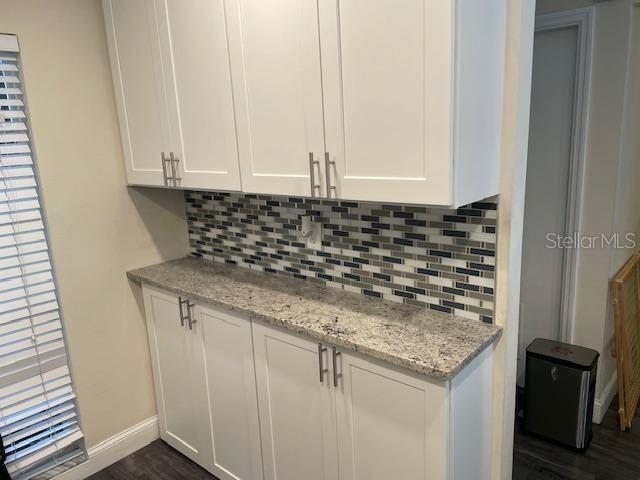 A kitchen area features white cabinets, a granite countertop, and a multi-colored tile backsplash — 5112 BAYSHORE BOULEVARD, TAMPA, FL