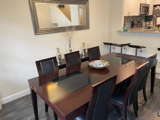 A dining room features a dark wood table with black chairs and a large wall mirror — 5112 BAYSHORE BOULEVARD, TAMPA, FL