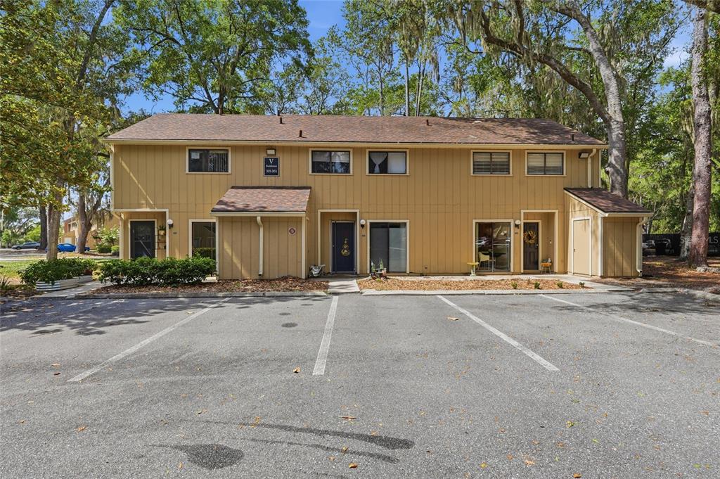 A two-story tan apartment building with a parking lot in the foreground — 507 NW 39TH ROAD UNIT 301, GAINESVILLE, FL