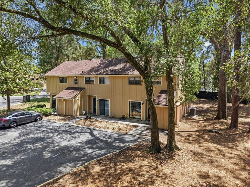 A two-story tan apartment building with a brown shingled roof sits near a parking lot — 507 NW 39TH ROAD UNIT 301, GAINESVILLE, FL