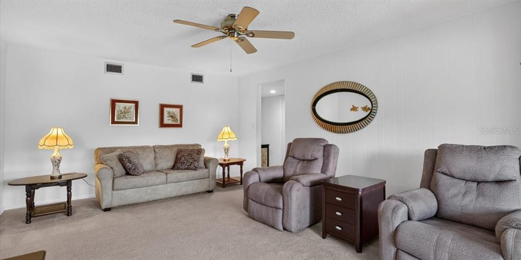 A living room features a sofa, two recliners, side tables, lamps, and a ceiling fan — 3595 40TH AVENUE S UNIT 2, ST PETERSBURG, FL
