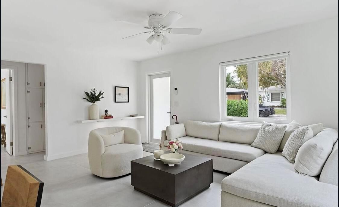 A bright living room features a white sectional sofa, a round armchair, and a coffee table — 1612 N N Street, FL 33460, FL