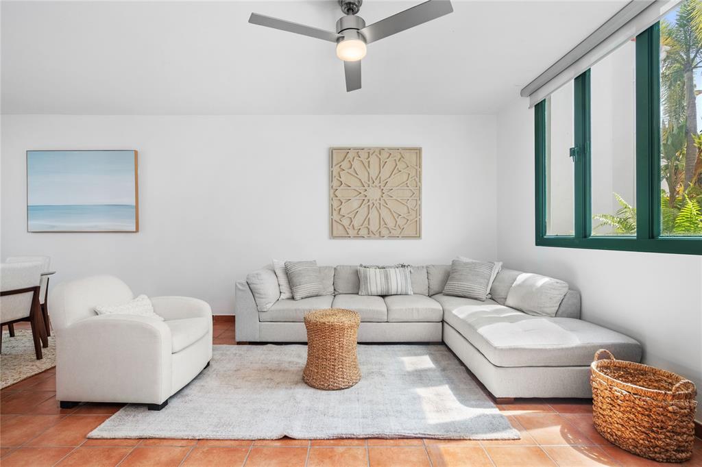 A living room features a light gray sectional sofa, an armchair, and terracotta tile flooring — 1601 RIO MAR VILLAGE UNIT 1601, RIO GRANDE, PR