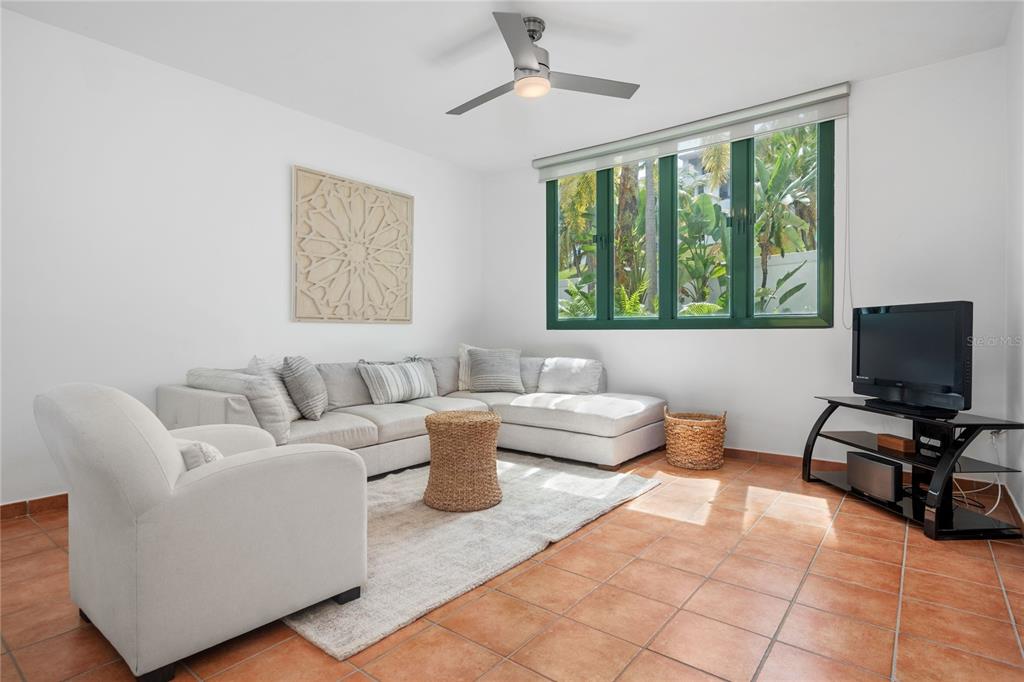 A living room features a sectional sofa, an armchair, a television, and tile flooring — 1601 RIO MAR VILLAGE UNIT 1601, RIO GRANDE, PR