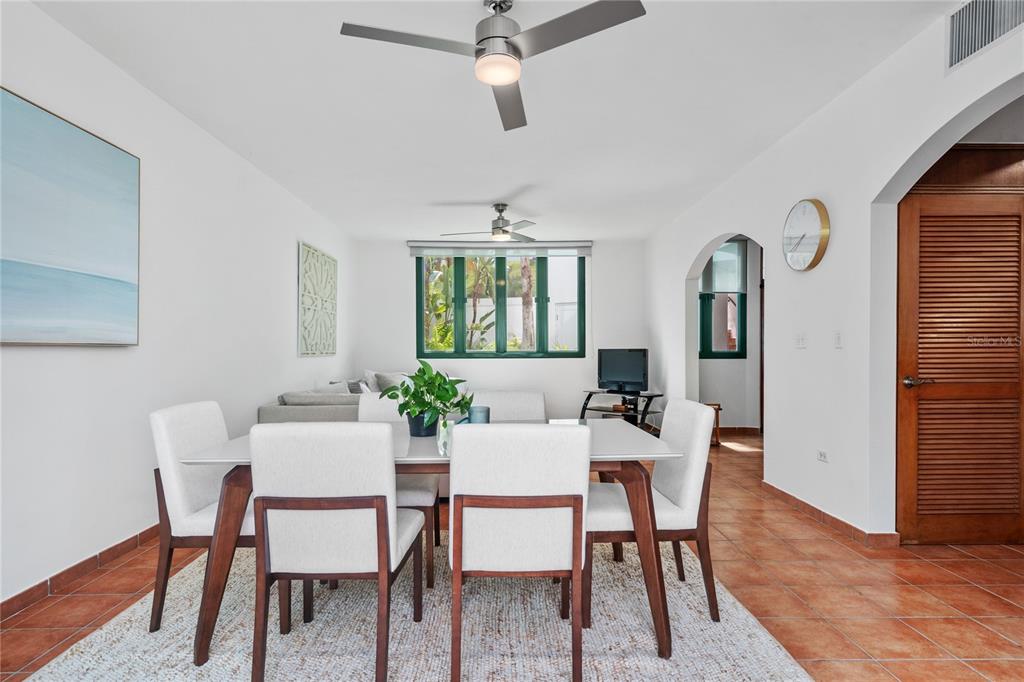 A dining area with a white table and chairs sits before a living room space — 1601 RIO MAR VILLAGE UNIT 1601, RIO GRANDE, PR