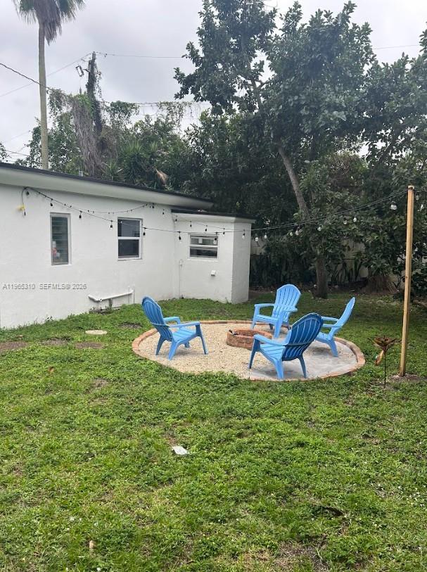 A backyard features a gravel fire pit area with four blue Adirondack chairs — 1220-1222 NE 110th Ter, Miami FL 33161, MIAMI, FL