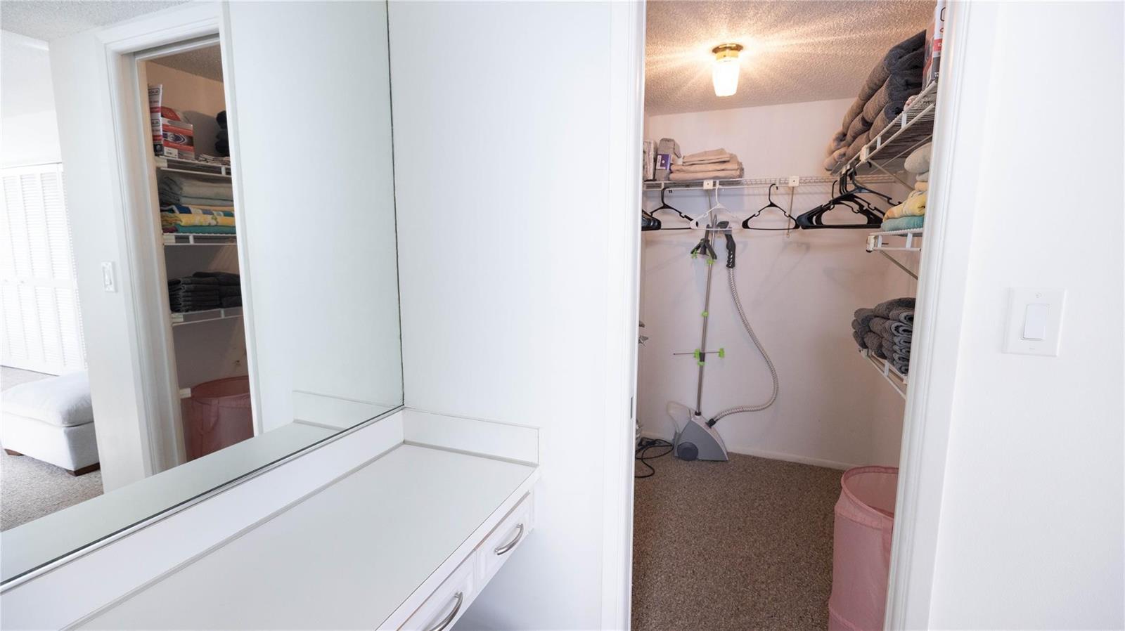 A walk-in closet with wire shelving, a garment steamer, and a vanity area with mirror — 3100 N Course Lane # 510, Pompano Beach FL 33069, POMPANO BEACH, FL