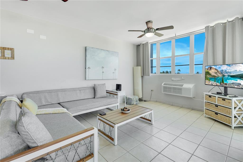 A living room features a gray sectional sofa, a wooden coffee table, and tile flooring — 115 115 UNIT 401, RINCON, PR