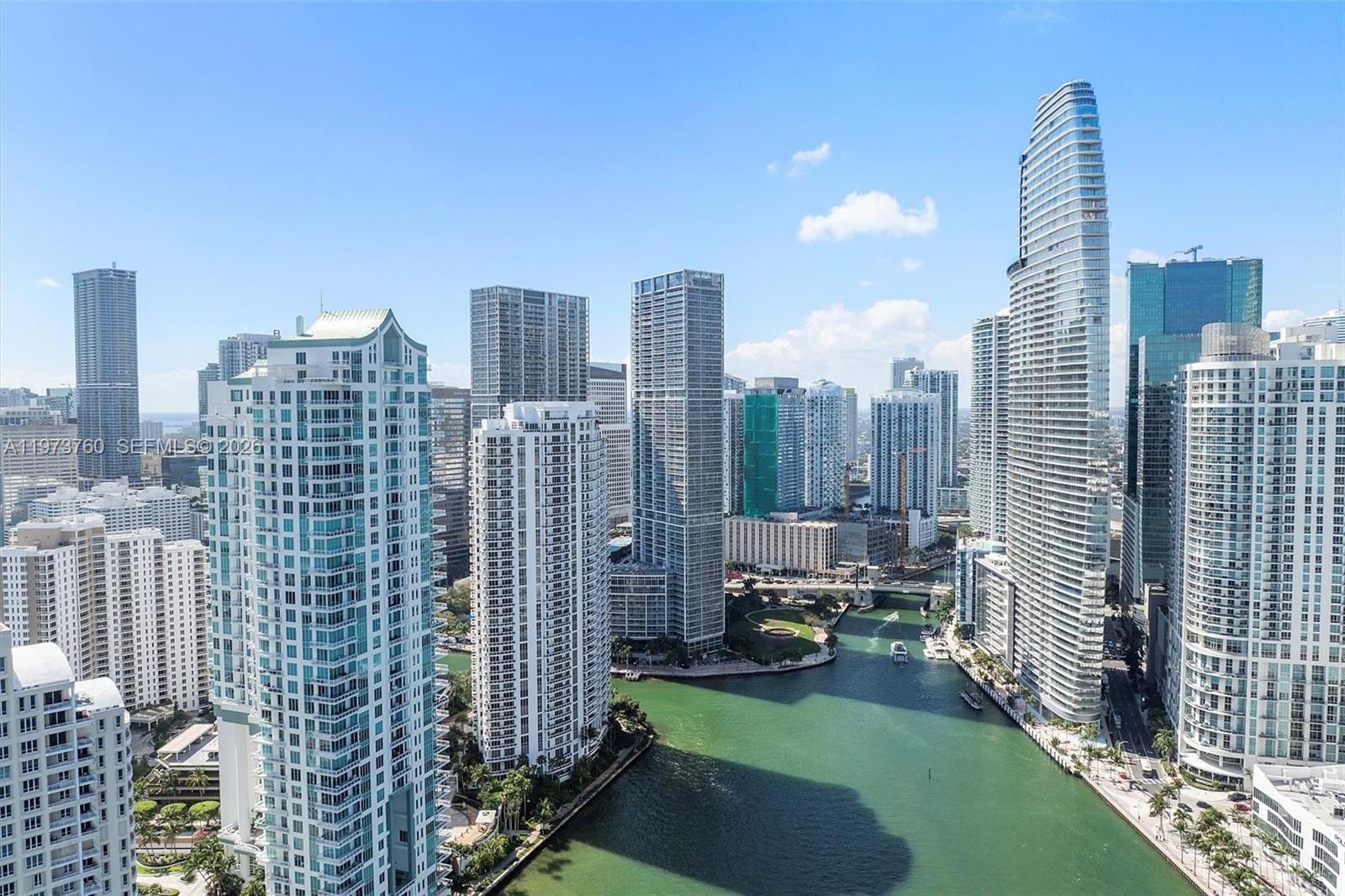 An aerial view of a city skyline featuring numerous high-rise buildings along a river — 300 Biscayne Blvd Way # 903, Miami FL 33131, MIAMI, FL