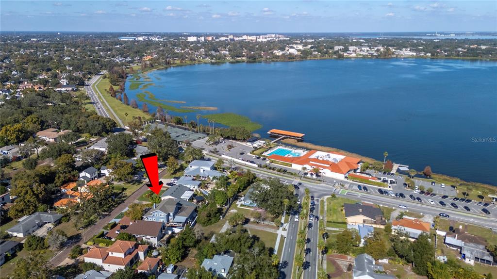 An aerial view shows a residential neighborhood situated along the shore of a large lake — 2214 COVENTRY AVENUE, LAKELAND, FL