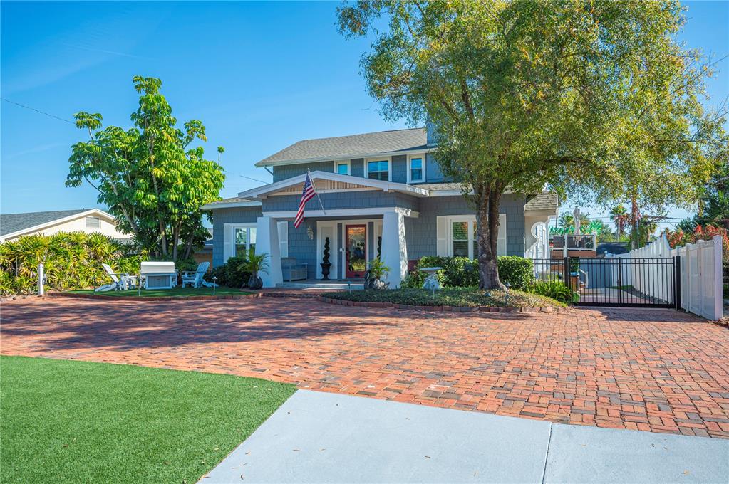 A two-story house with gray siding and a brick driveway sits behind a front lawn — 2214 COVENTRY AVENUE, LAKELAND, FL