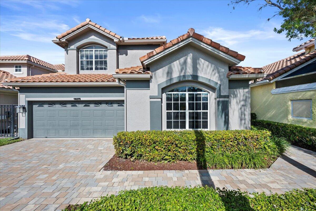 A two-story house with a gray stucco exterior, a tiled roof, and a paved driveway — 10375 Osprey Trace, West Palm Beach FL 33412, WEST PALM BEACH, FL