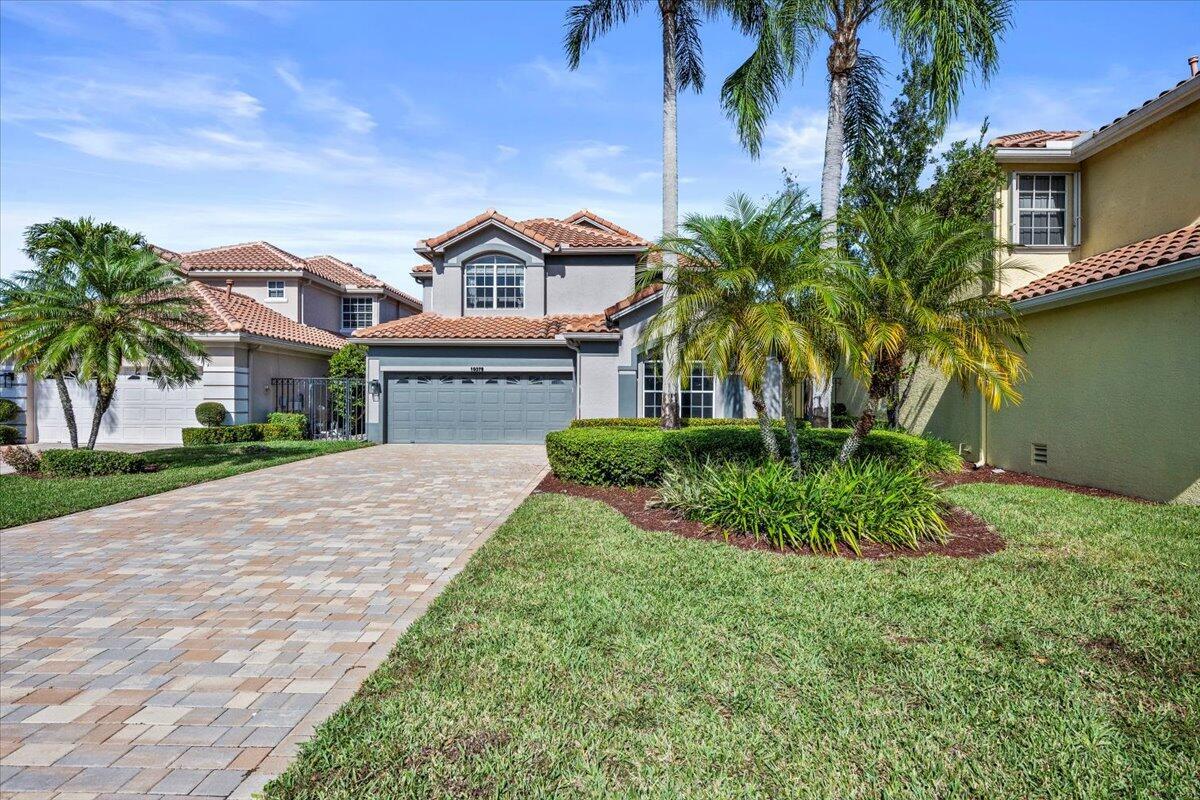A two-story suburban house with a paved driveway, a two-car garage, and palm trees — 10375 Osprey Trace, West Palm Beach FL 33412, WEST PALM BEACH, FL