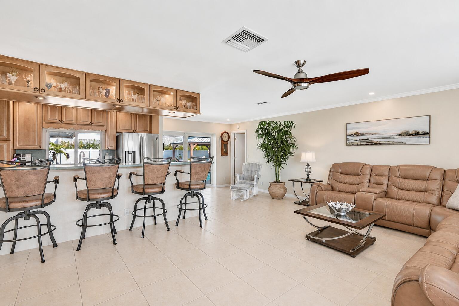 An open-concept living room and kitchen featuring a large island, sectional sofa, and floor-to-ceiling windows — 3001 NE 45th Street, Lighthouse Point FL 33064, LIGHTHOUSE POINT, FL