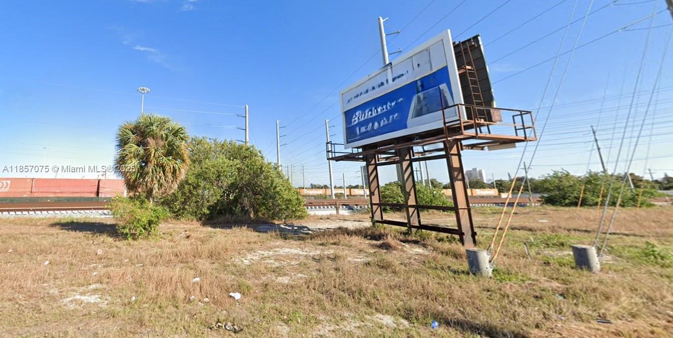 A large billboard stands in a grassy, undeveloped lot near a railroad track — 0 Dixie Hwy, Riviera Beach FL 33404, RIVIERA BEACH, FL