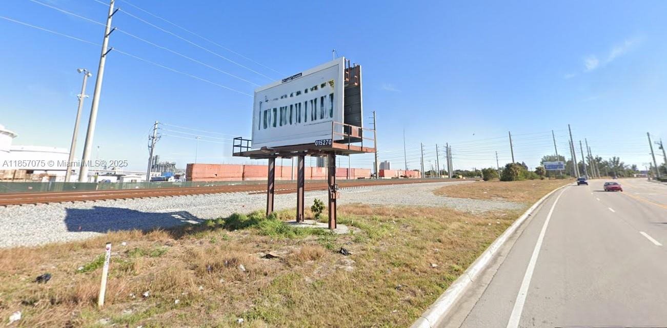 A large billboard stands next to a road and railroad tracks under a clear sky — 0 Dixie Hwy, Riviera Beach FL 33404, RIVIERA BEACH, FL