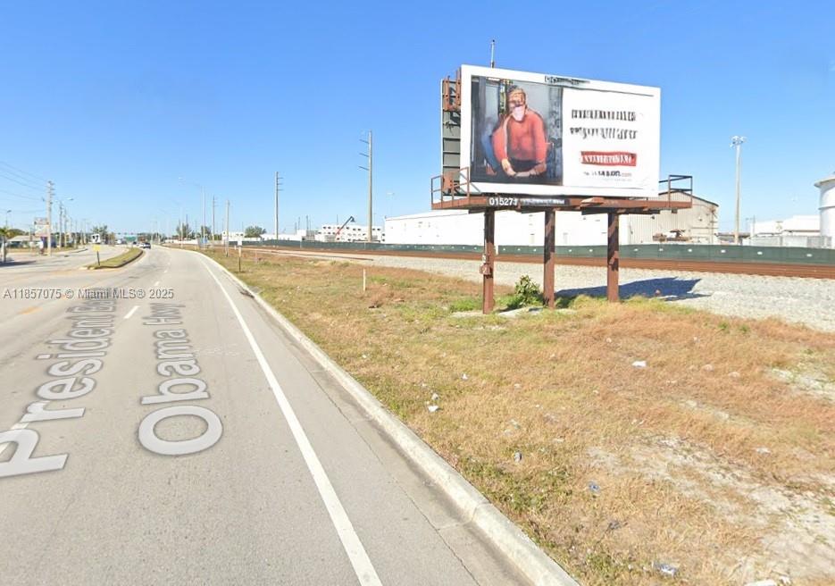 A billboard stands beside a paved road with a railroad track in the background — 0 Dixie Hwy, Riviera Beach FL 33404, RIVIERA BEACH, FL