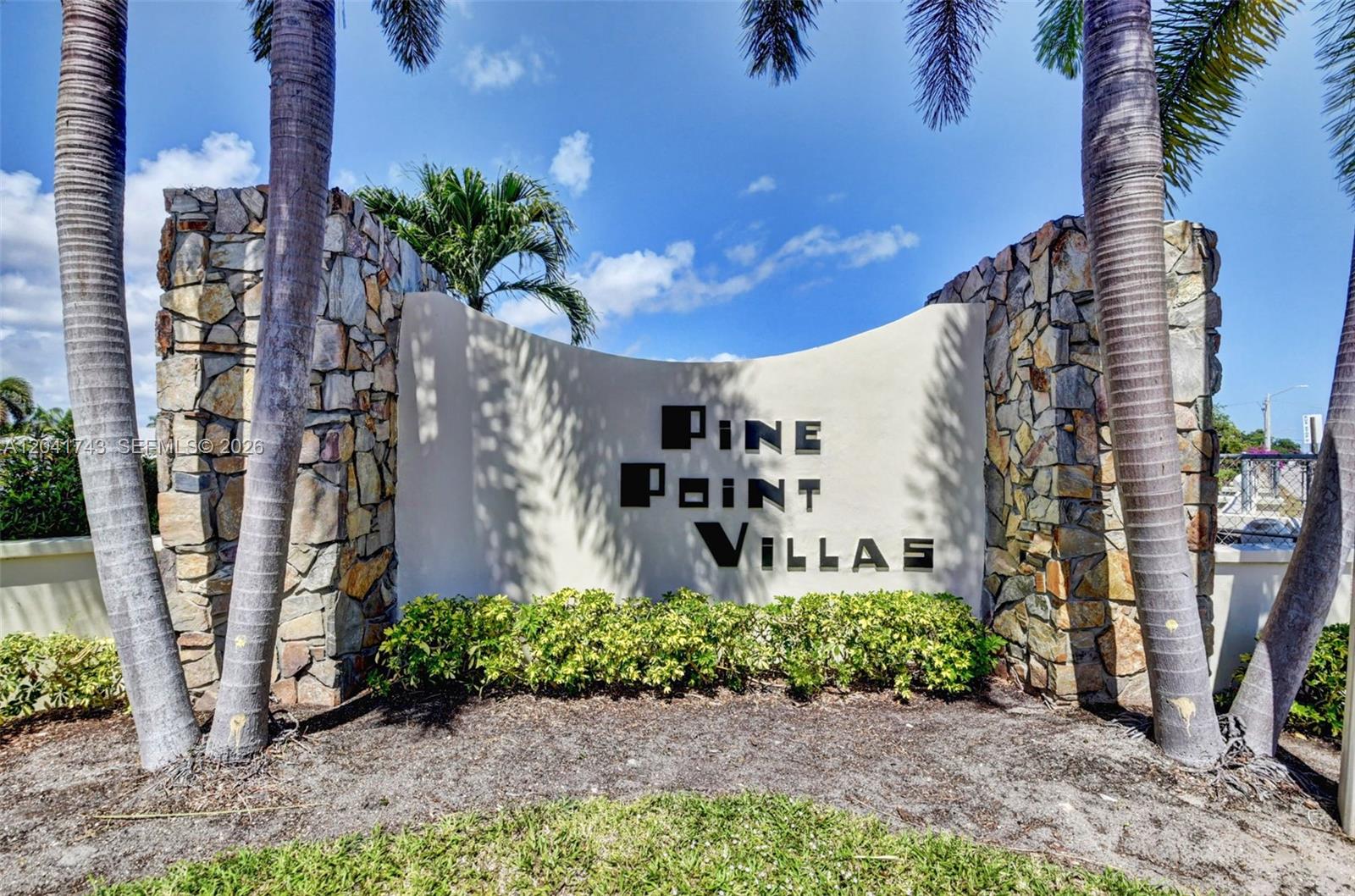 A stone-accented entrance sign for Pine Point Villas stands between two tall palm trees — 3241 Ridge Hill Rd, Boynton Beach FL 33435, BOYNTON BEACH, FL