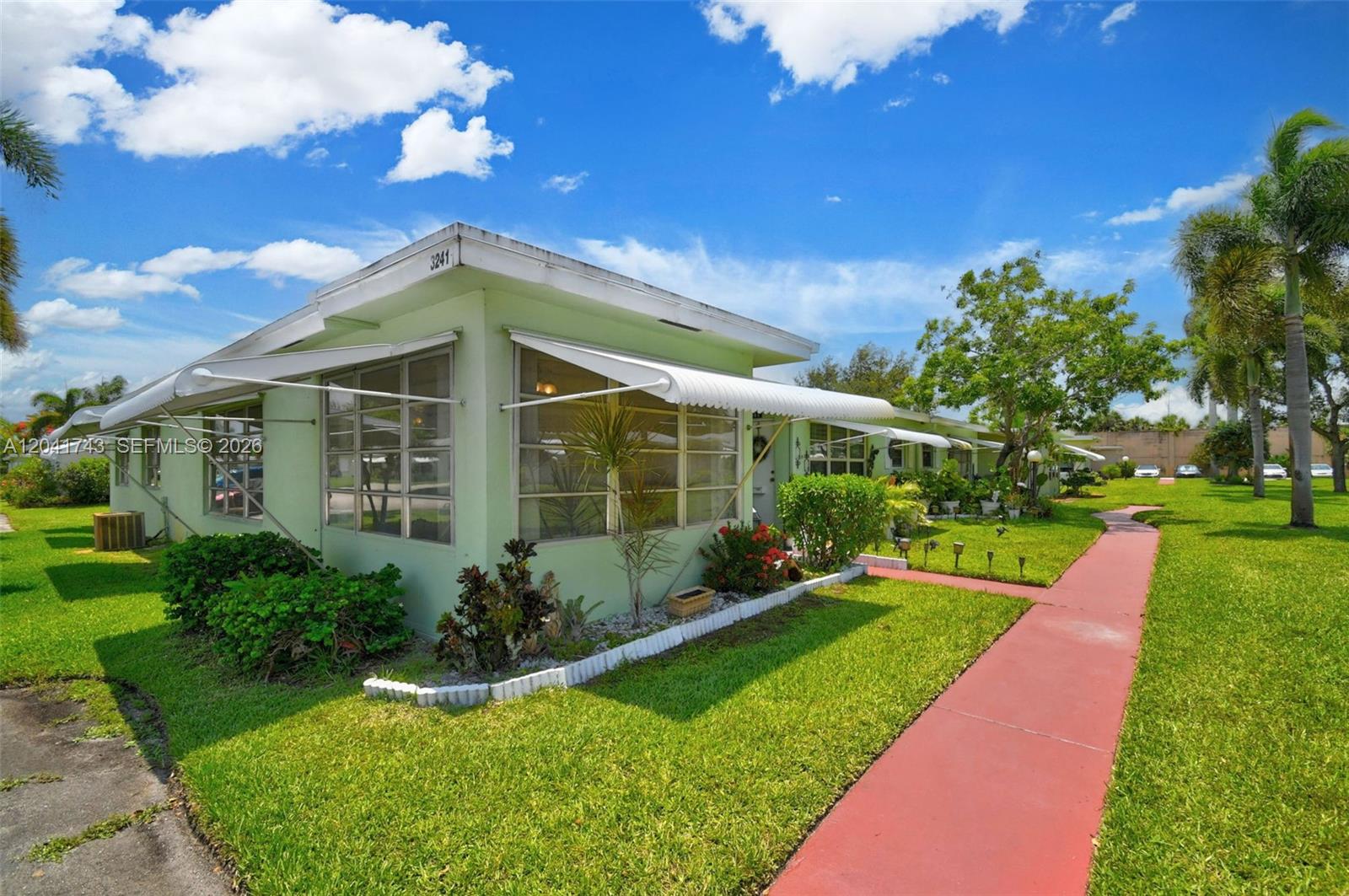 A light green single-story building features a flat roof, metal awnings, and a red walkway — 3241 Ridge Hill Rd, Boynton Beach FL 33435, BOYNTON BEACH, FL