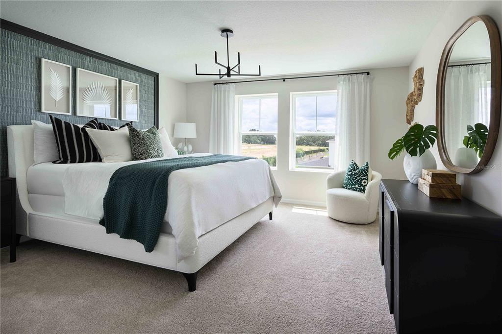 A bedroom features a white bed, a dark accent wall, and a round wall mirror — 6059 PRAIRIE RUN, HAINES CITY, FL