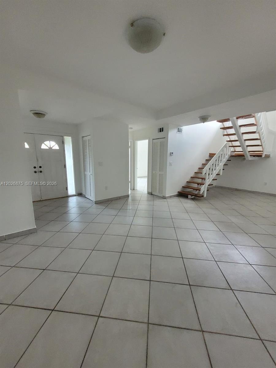 An interior view shows a tiled living area with a staircase and white doors — 2438 SW 109th Ct, Miami FL 33165, MIAMI, FL
