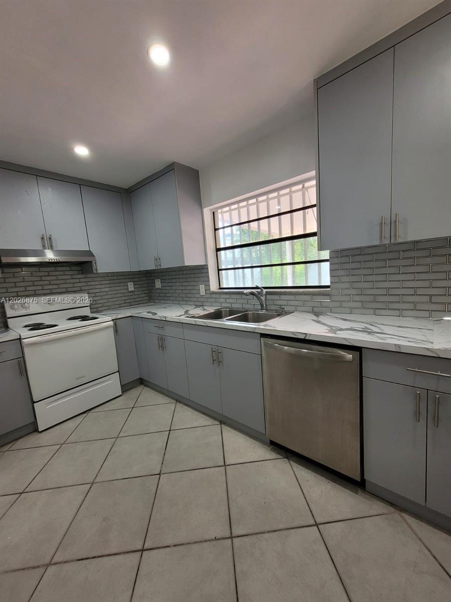 A kitchen features gray cabinets, white marble-patterned countertops, a white stove, and tiled floors — 2438 SW 109th Ct, Miami FL 33165, MIAMI, FL