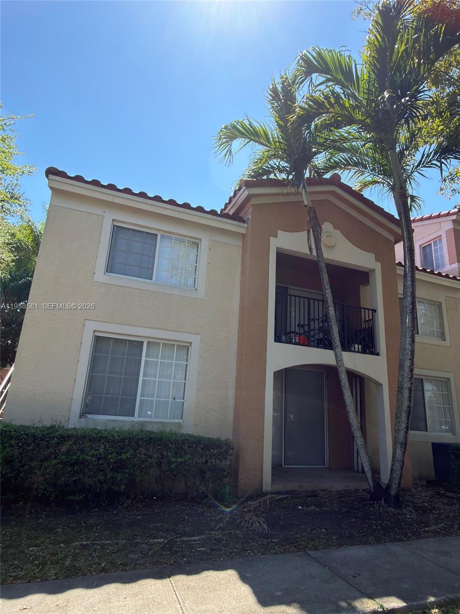 A two-story stucco apartment building features a recessed balcony and palm trees in front — 2173 Renaissance Blvd # 101, Miramar FL 33025, MIRAMAR, FL
