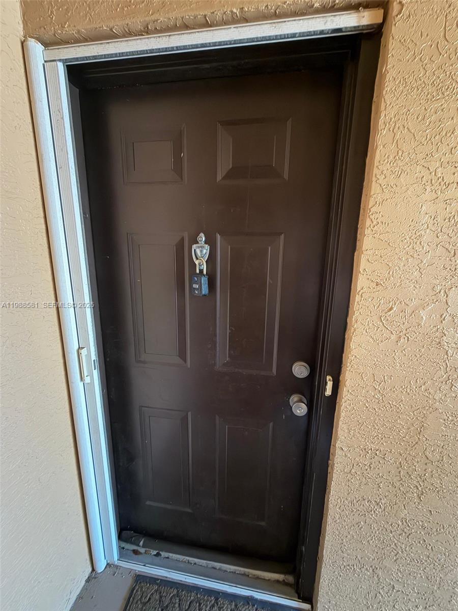A dark brown front door with a lockbox attached to the door knocker — 2173 Renaissance Blvd # 101, Miramar FL 33025, MIRAMAR, FL