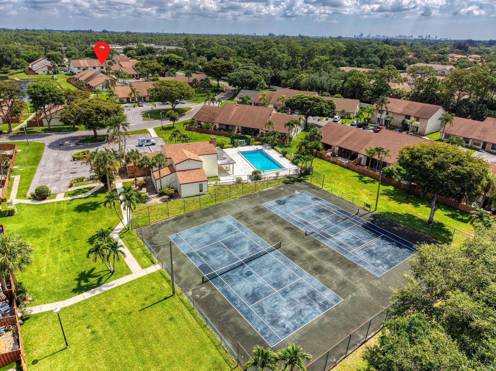 An aerial view shows a residential complex with tennis courts, a swimming pool, and buildings — 1030 Parkside Green Drive # A, FL 33415, FL