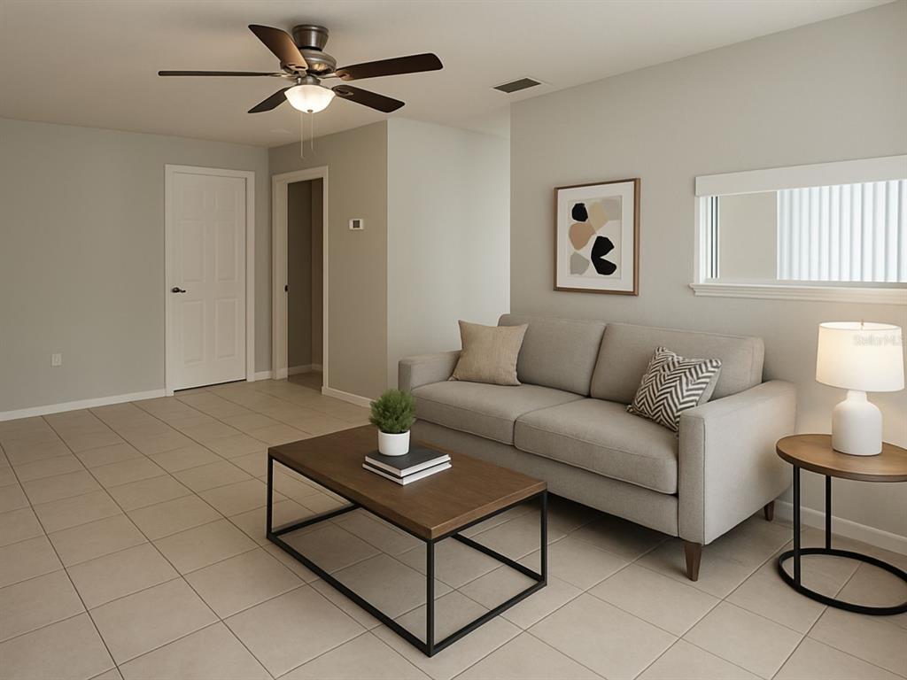 A living room features a beige sofa, a wood coffee table, and tile flooring — 2359/2361 CHESTNUT HILLS DRIVE, LAKELAND, FL