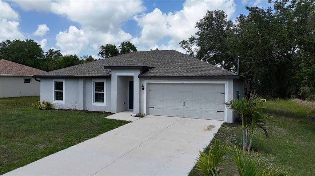 A single-story house with a gray stucco exterior, a two-car garage, and a concrete driveway — 4127 SNOWDROP STREET, NORTH PORT, FL
