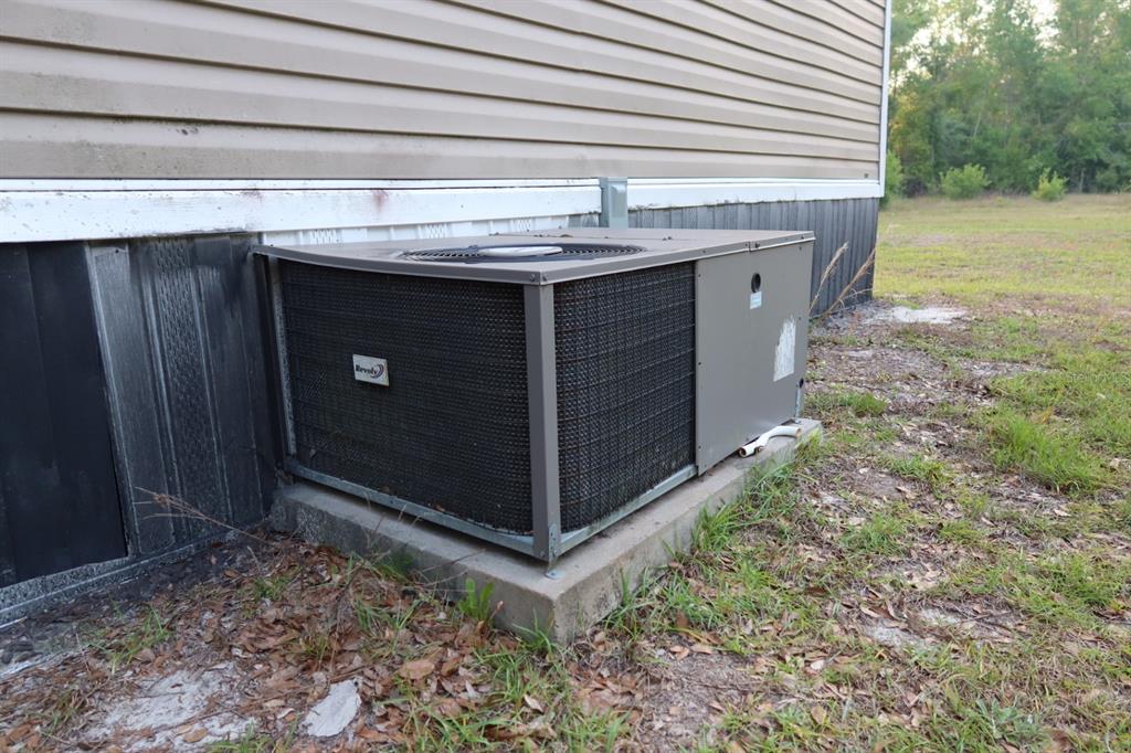 An outdoor HVAC unit sits on a concrete pad beside a mobile home exterior — 11533 E US 90, MADISON, FL