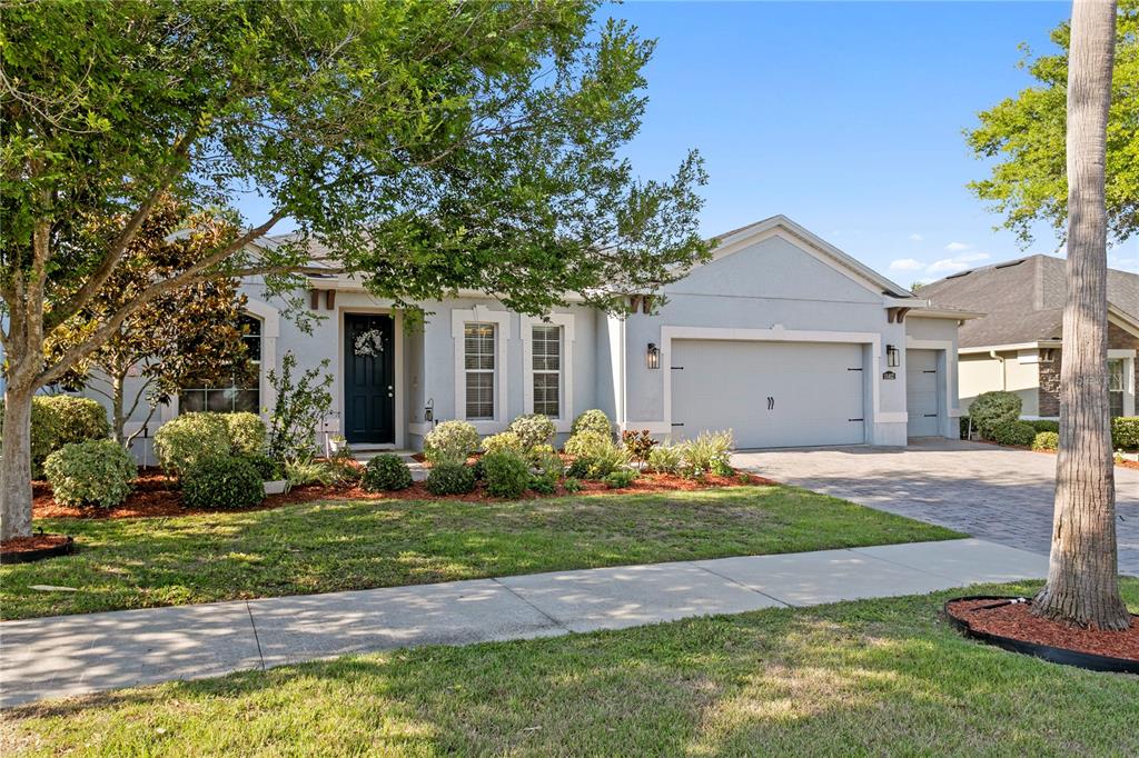A single-story house with a light-colored stucco exterior, a two-car garage, and a landscaped yard — 11412 LAKE LUCAYA DRIVE, RIVERVIEW, FL