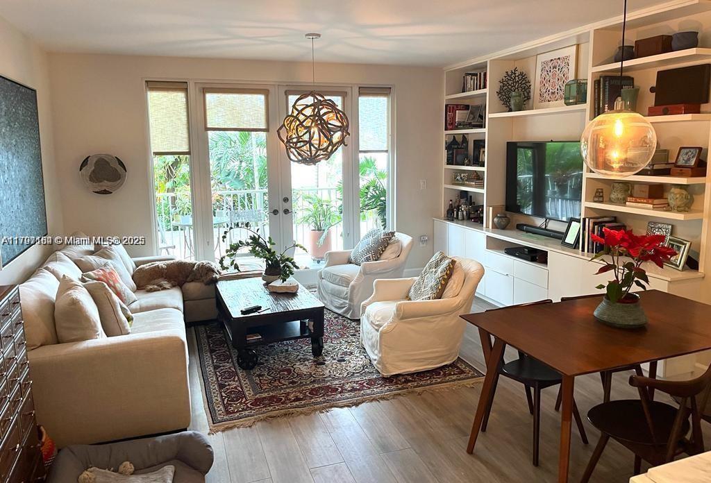 A living room features a sectional sofa, two armchairs, a dining table, and built-in shelving — 3540 Main Hwy # 204, Miami FL 33133, MIAMI, FL