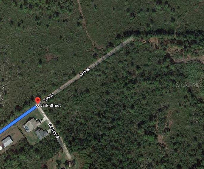 This is a satellite map view showing a residential street intersection surrounded by wooded land — 569 KENNEDY STREET, LAKE PLACID, FL
