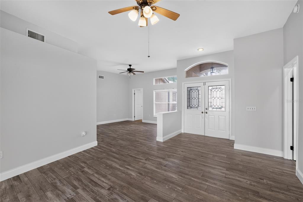 An entryway with wood-look flooring, a ceiling fan, and a double front door with glass inserts — 12421 WINDSWEPT AVENUE, RIVERVIEW, FL