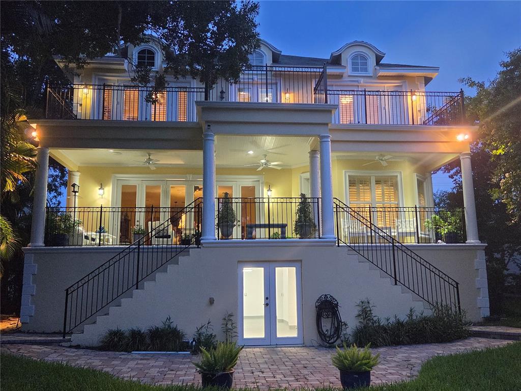 The rear exterior of a three-story yellow house features a raised porch and balcony — 3312 N PERRY AVENUE, TAMPA, FL